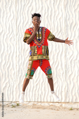 African American guy in national clothes on a background of a white wall