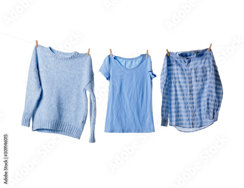 Clean clothes hanging on rope against white background