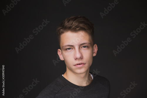 Beauty portrait of a beautiful young brown haired man on a gray background