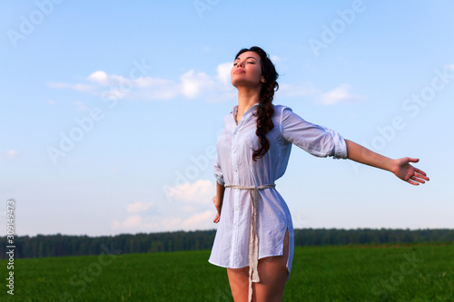 Pretty woman enjoys clear air in the summer field Fototapeta