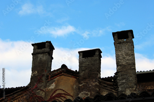 Tre vecchi comignoli con cielo photo