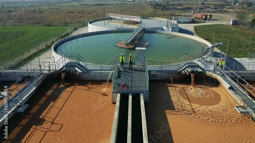Engineers assessing waste water treatment plant with industrial drone