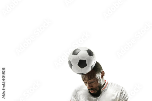 Fototapeta Naklejka Na Ścianę i Meble -  Close up of emotional african man playing soccer hitting the ball with the head on isolated white background. Football, sport, facial expression, human emotions, healthy lifestyle concept. Copyspace.