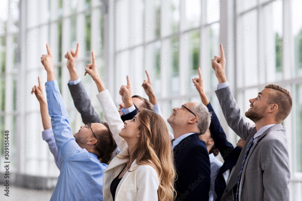 people, goals and corporate concept - happy business team pointing finger up at office people, goals and corporate concept - happy business team pointing finger up at office