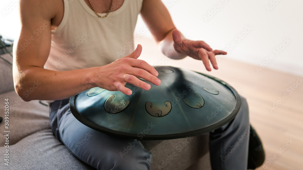 Close up of man hands playing hang drum indoors. Unusual music instrument.  Stock-Foto | Adobe Stock