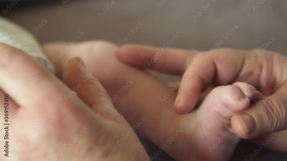 Grandparent's Hands Holding And Playing With Their Newborn Grandchild - Close Up Shot Grandparent's Hands Holding And Playing With Their Newborn Grandchild - Close Up Shot