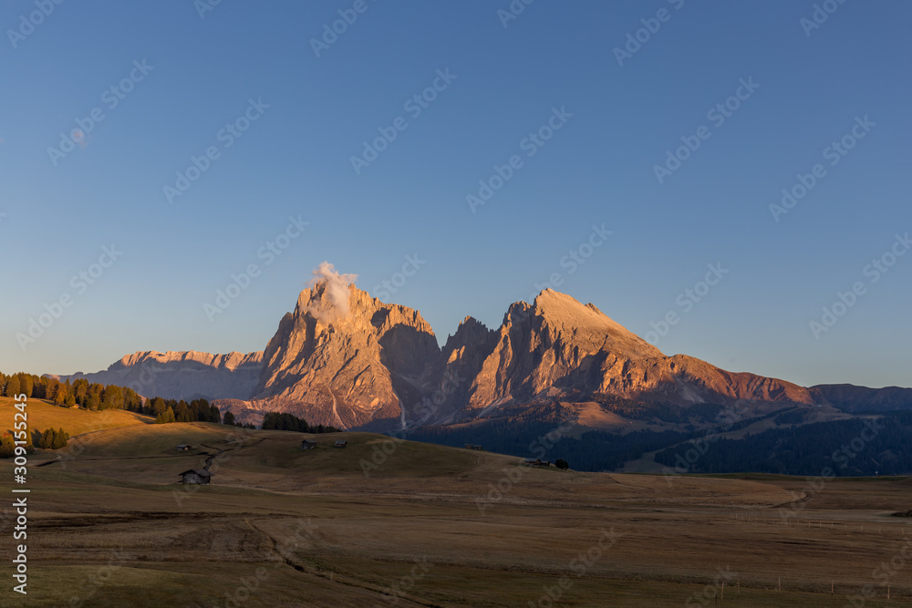 Sunset landscapes on Alpe di Siusi with Sassolungo or Langkofel Mountain Group in Background in autumn, South Tyrol, Italy