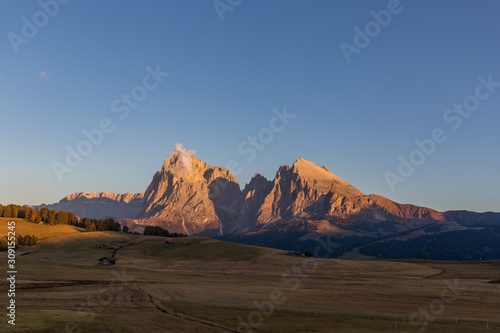 Sunset landscapes on Alpe di Siusi with Sassolungo or Langkofel Mountain Group in Background in autumn, South Tyrol, Italy