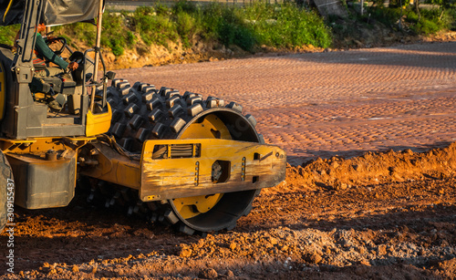 Soil compactor with vibratory padfoot drum. Heavy duty machinery working on highway construction site. Vehicle for soil compaction. Road construction equipment. Paving. Compaction of the road.