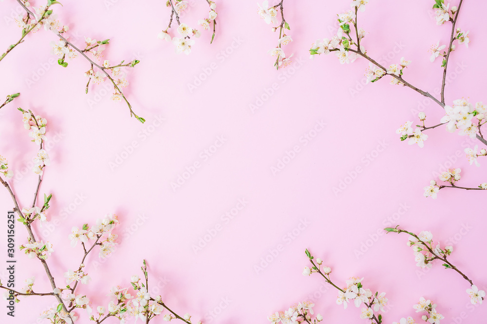 Fototapeta premium Floral frame with white flowers on pink background. Flat lay, top view. Spring background.