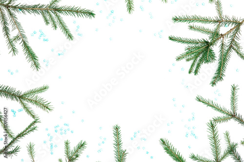 Christmas frame of branches with blue snowflakes on white background. Flat lay