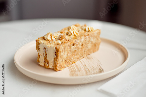 Coffee cake. A piece of cake on a plate. Sweet dessert on a round pink with a plate wooden background. Close-up.