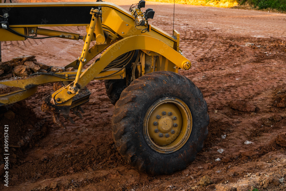 Grader is working on road construction. Grader industrial machine on construction of new roads. Heavy duty machinery working on highway. Construction equipment. Compaction of the road. Grader is working on road construction. Grader industrial machine on construction of new roads. Heavy duty machinery working on highway. Construction equipment. Compaction of the road.