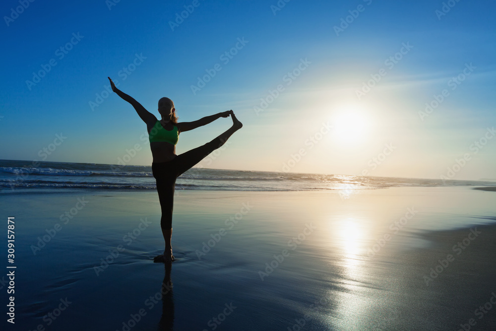 Black silhouette of active woman stretching at yoga retreat on sunset beach, sky with sun, ocean surf background. Travel lifestyle, people outdoor activity, family summer vacation on tropical island.