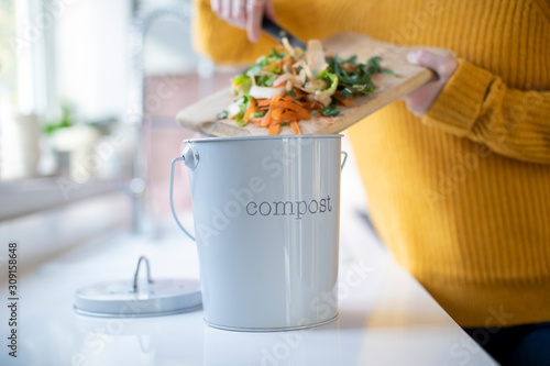 Close Up Of Woman Making Compost From Vegetable Leftovers In Kitchen photo