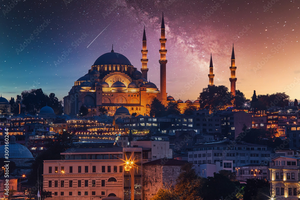 Fototapeta premium Widok na molo Eminonu i meczet Sulejmana Wspaniałego po drugiej stronie Zatoki Złoty Róg w gwiaździstą noc
