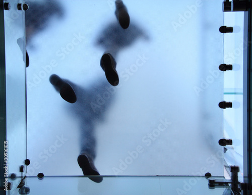 Feet of people who standing on translucent glass