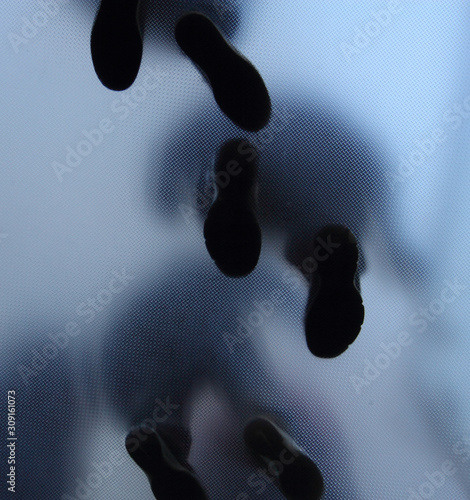 Feet of people who standing on translucent glass