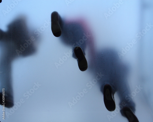 Feet of people who standing on translucent glass
