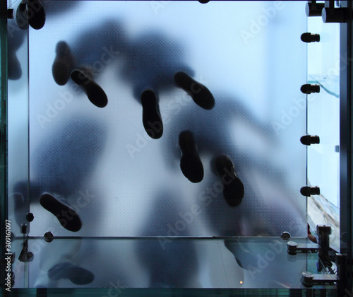 Feet of people who standing on translucent glass