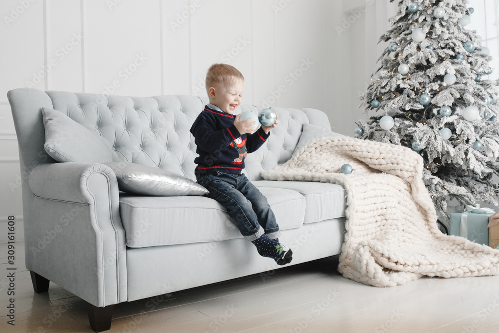 Little boy sitting on the sofa with the toy in his hand Little boy sitting on the sofa with the toy in his hand