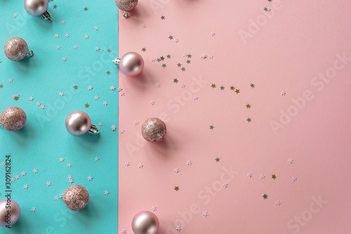 Christmas balls and confetti on a blue and pink background  New Year concept. Top view  flat lay  copy space.