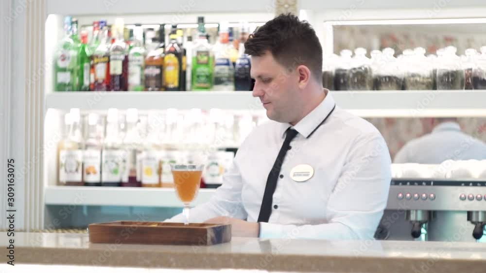The bartender serves a cocktail of blood and sand using a gas burner The bartender serves a cocktail of blood and sand using a gas burner