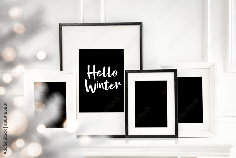 White frames on fireplace shelf and free space for your decoration.White wall decoration and christmas time. White frames on fireplace shelf and free space for your decoration.White wall decoration and christmas time.