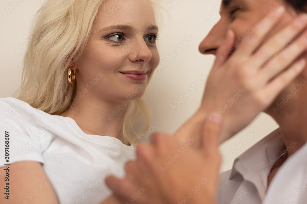 Selective focus of smiling girl touching boyfriend face Selective focus of smiling girl touching boyfriend face