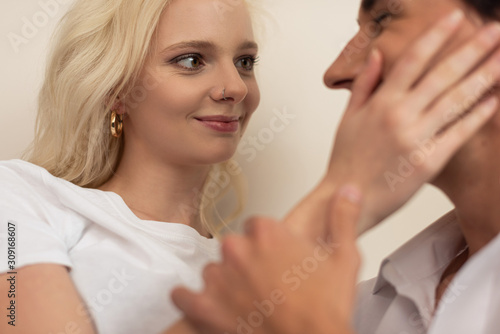 Selective focus of smiling girl touching boyfriend face