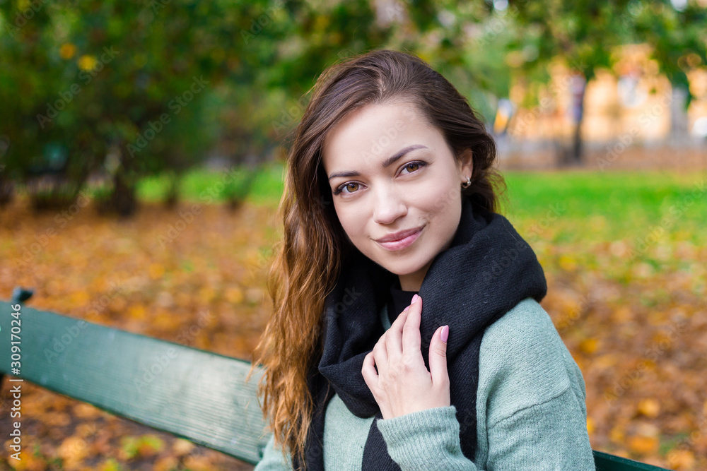 Beautiful girl sitting on a bench, sunny autumn day in the park, relaxing, Portrait of stylish smiling happy woman after work or study Beautiful girl sitting on a bench, sunny autumn day in the park, relaxing, Portrait of stylish smiling happy woman after work or study