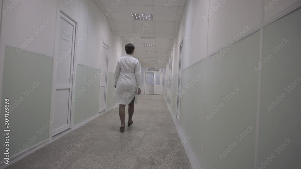 Woman doctor walks down the hospital corridor Woman doctor walks down the hospital corridor
