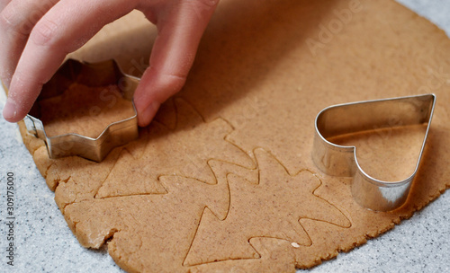 Christmas and New Year celebration traditions, homemade gingerbread cookies, child hands with Christmas molds on dough