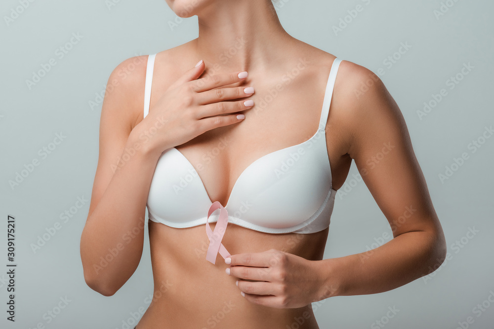 cropped view of girl in white bra holding pink ribbon as breast cancer awareness isolated on grey