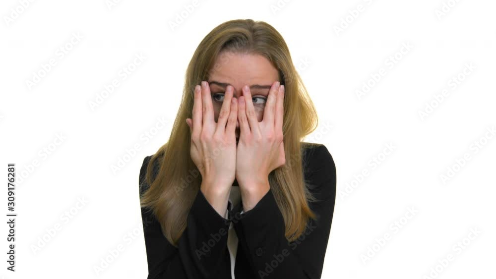 The terrified girl covers her face with her hands. Studio portrait on white background. The terrified girl covers her face with her hands. Studio portrait on white background.