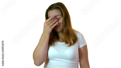Plus size woman in studio feeling discomfort and suffering sinus chronic inflammation. Showing painfull expression and touching her temple.
