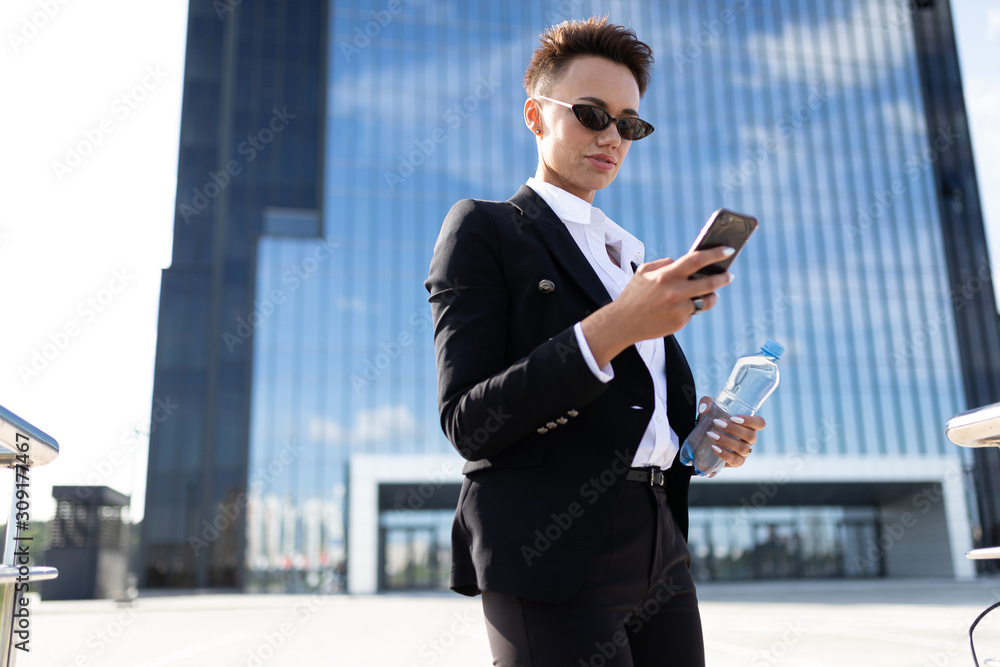 Caucasian woman in office clothes waits colleague near the office building Caucasian woman in office clothes waits colleague near the office building