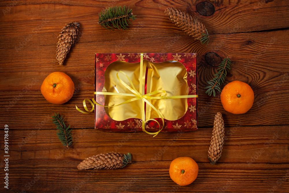 Christmas gift in golden pouch bags, red present box wrapped with New year decorations on rustic wooden background. Trendy tea,coffee packaging mockup, flatlay style.Copy space,winter holidays concept Christmas gift in golden pouch bags, red present box wrapped with New year decorations on rustic wooden background. Trendy tea,coffee packaging mockup, flatlay style.Copy space,winter holidays concept