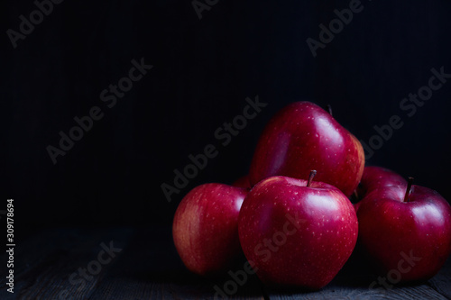 Red Braeburn Apples on rustic wood surface.
