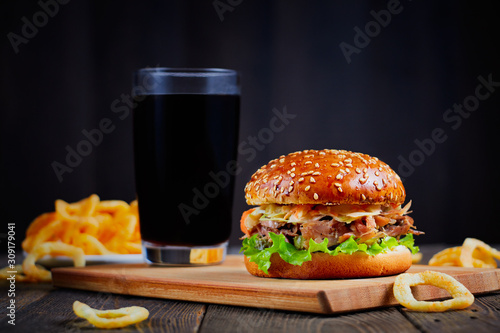 Delicious Burger on wooden table and dark background