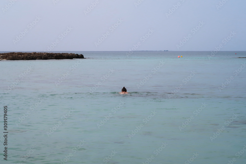 Girl floating in the sea near the shore