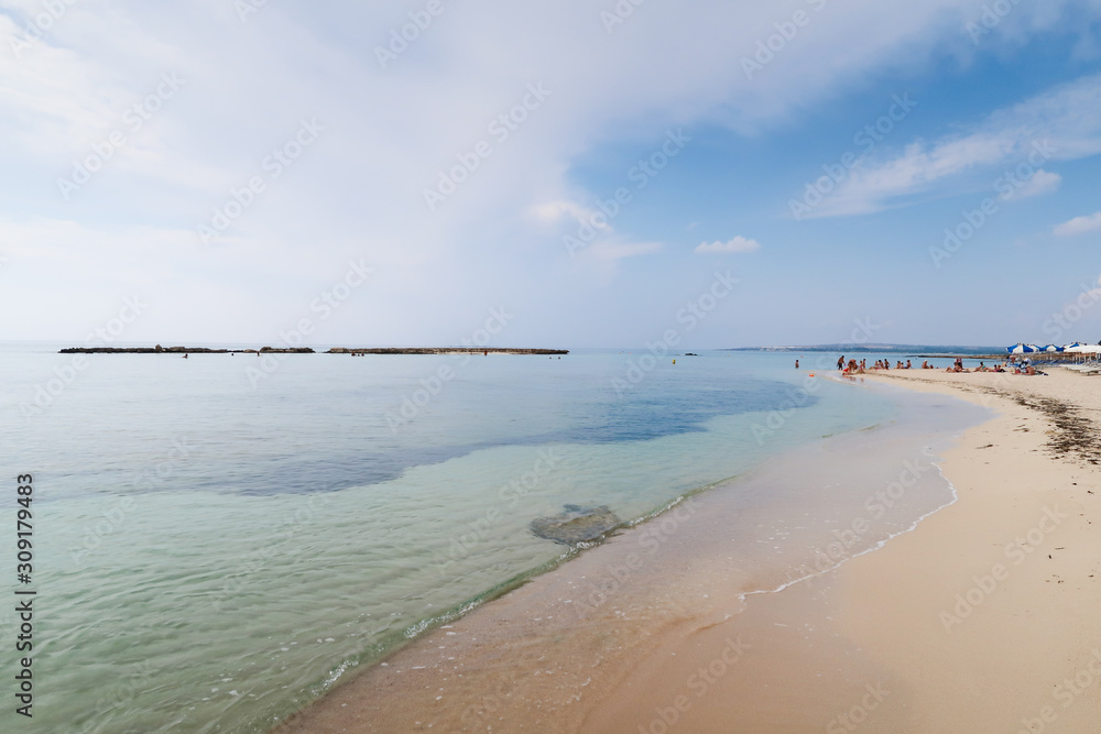 Obraz premium Sandy beach against blue sky and azure sea