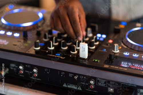 Wallpaper Mural club dj plays music on stage in nightclub.Hand of disc jockey adjusting sound track volume level.Professional audio equipment on music festival Torontodigital.ca