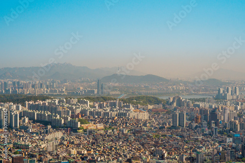Aerial view of Seoul with buildings, houses, hills and river.