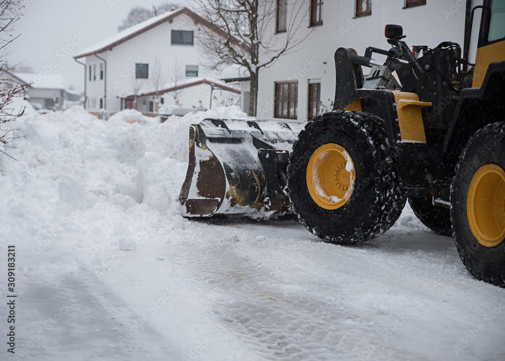 lots of snow on the street. tractor clears the snow with the loader lots of snow on the street. tractor clears the snow with the loader