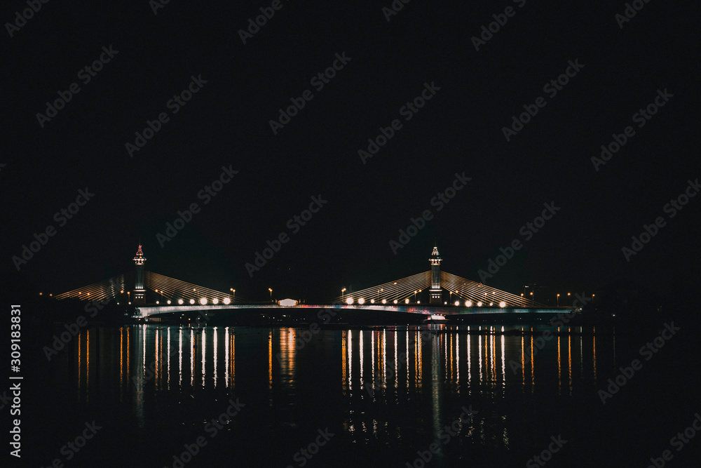view of night scenery of city in Thailand  with beautiful reflections of skyscrapers and bridges by riverside in twilight. Cityscape view of bridge crosses the Chao Phraya River