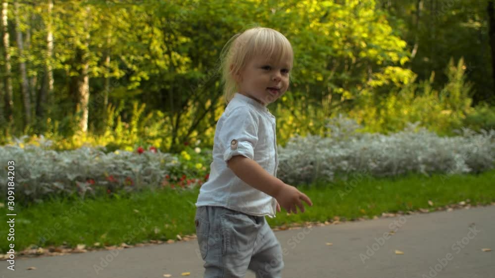 Little boy walking along the road in the park Little boy walking along the road in the park