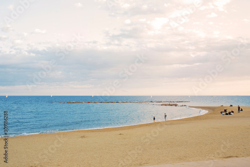 View of Barcelona beach  in the Barceloneta district  overlooking the Mediterranean Sea. The sky is dark and there are many waves.