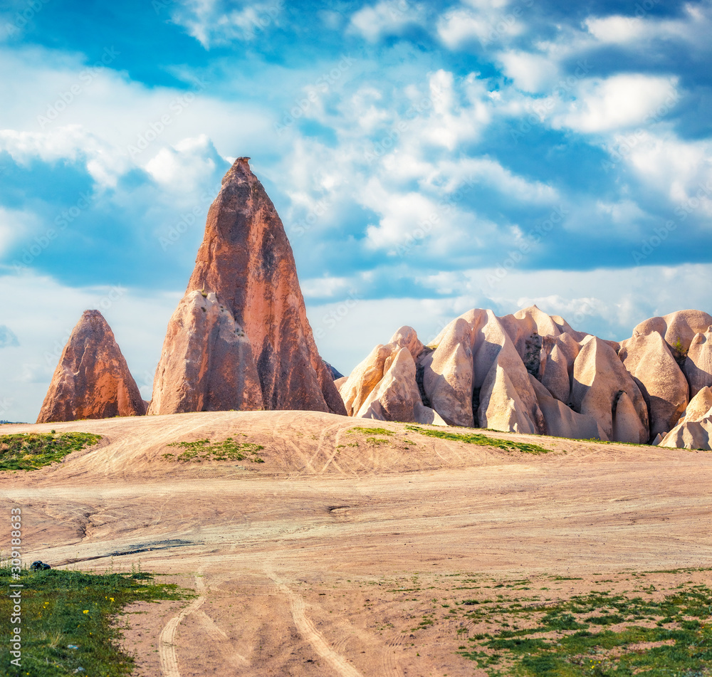 Fantactic summer scene of Cappadocia. Strange forms of limestone peaks in Red Rose valley. Cavusin village located, district of Nevsehir, Turkey, Asia. Traveling concept background.
