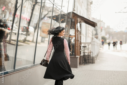 Beautiful woman in fashionable clothes walking through the streets of the city. photo